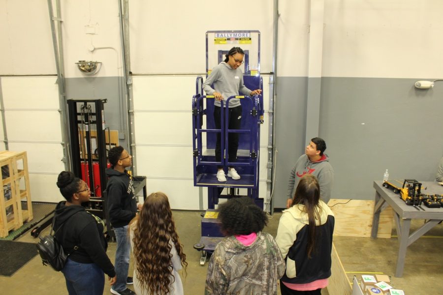 Tasheena Williams rides a lift while touring the Distribution Center at Career Tech East on Feb. 28.