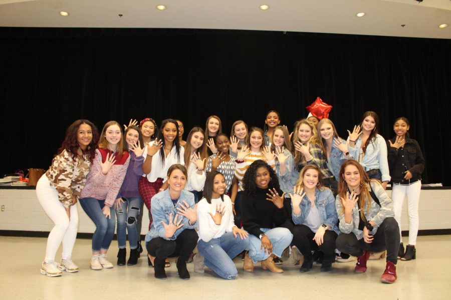 Members of the Center Hill Dance Team, along with their sponsor and coach, show off their state championship rings after a reveal ceremony March 19.