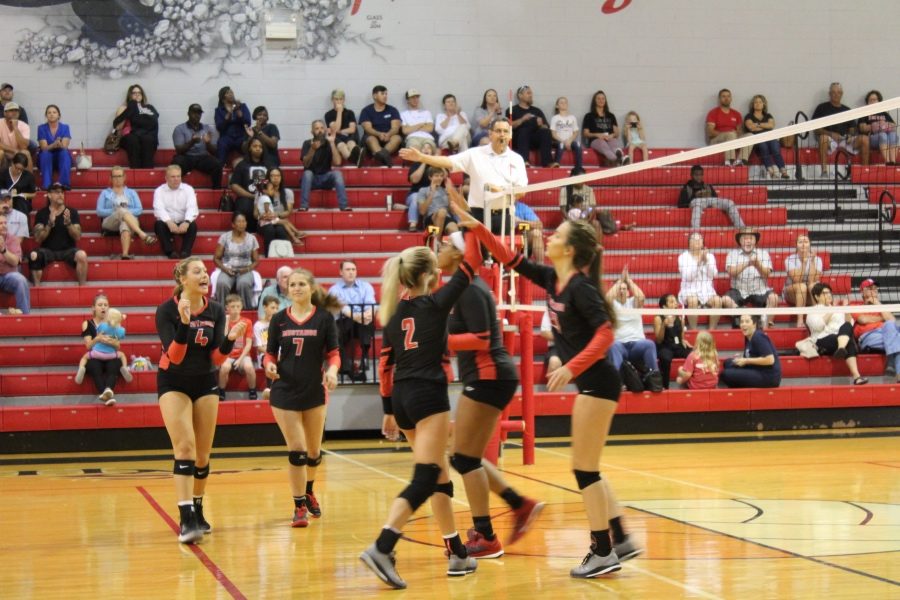 The varsity volleyball team celebrates during an Aug. 20 match against Southaven. The Mustangs won the home non-conference match 3-0.