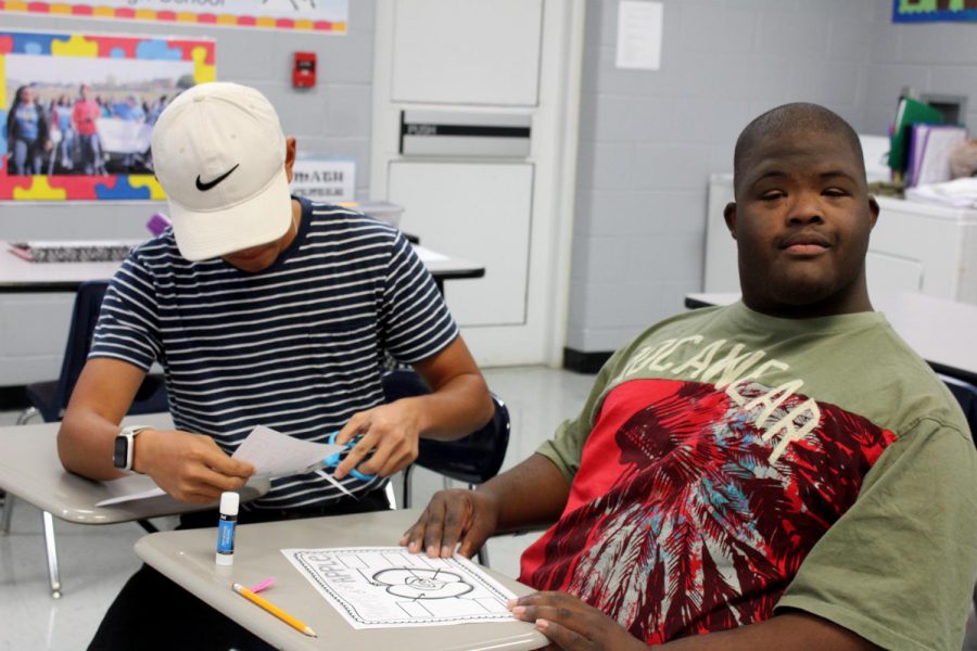 Duncan Van, left, a member of Interact’s Best Buddies program, works with William “Trey” Jones III on a craft in the community-based class. Trey was born with an extra chromosome, but that doesn’t mean he is any less.
