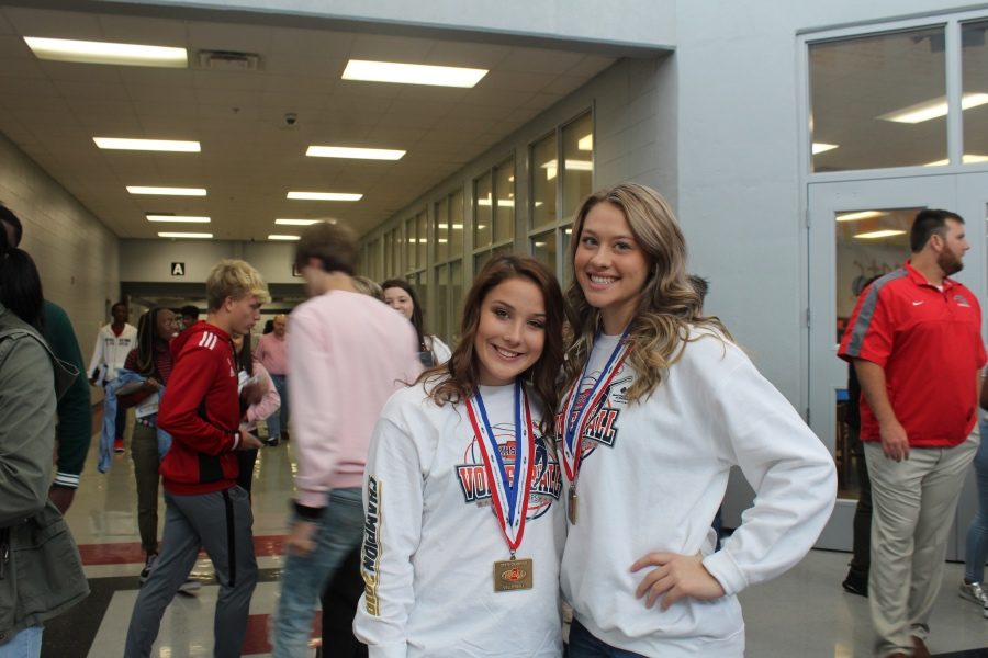 Makenzie Sandridge and Chloe Steen show off the medals they received when the volleyball team won the state championship Oct. 26.