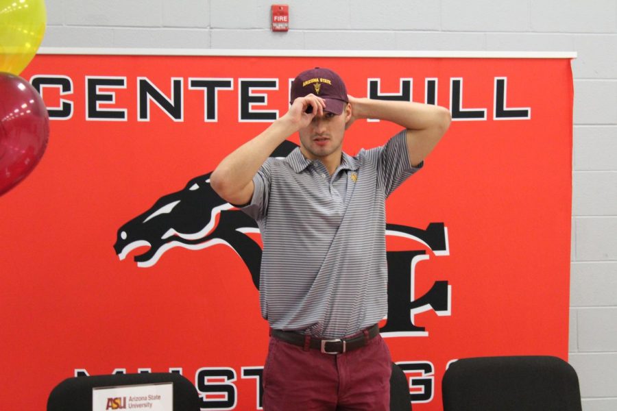 Taylor Williams puts on a Sun Devils hat at his signing today to swim for Arizona State University.