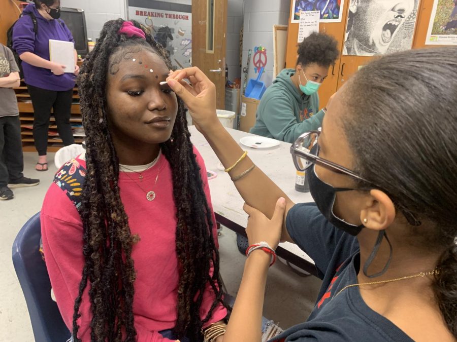 Art Society member Nia Ross paints Carmen Floyds face for tonights football game. The Mustangs will play Kirby at 7 in the first home game of the season.