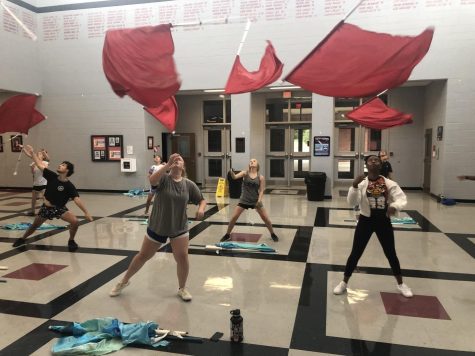 Front from left, senior Dalton South, junior Chloe Ratcliff and senior Jasmine Cole practice with the Color Guard after school in the Commons Aug. 30.