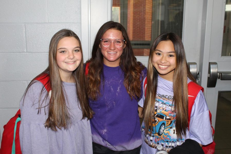 Cheerleaders, Lexi Burcham (left), Lorie Buckley (middle), and Trinity Nguyen (right), dress in purple for Domestic Violence Awareness.