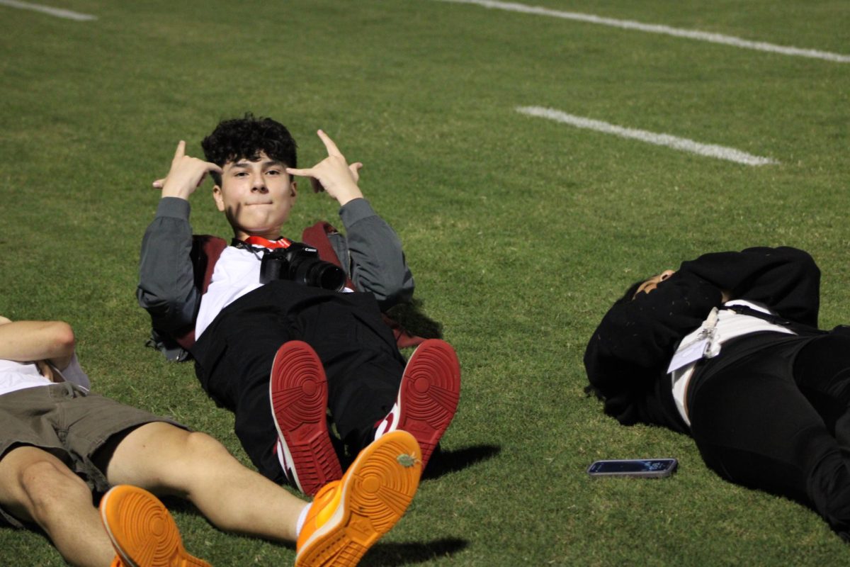 Multimedia Director and other Pony Express students goof off on the sidelines during half-time.