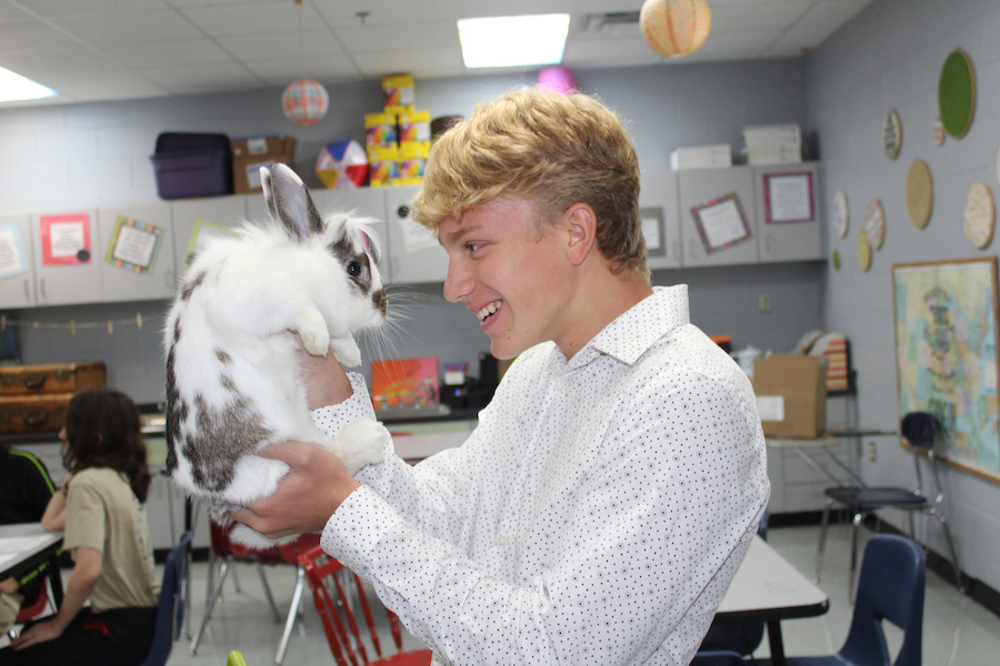 Freshman Caden Tackett holds Oreo, one of the pets in Kerry Matthews’s biology classroom. Matthews also has two cockatiels named Chainsaw and Pickles and a betta fish named Mr. Coffee because it lives in an old coffee pot.