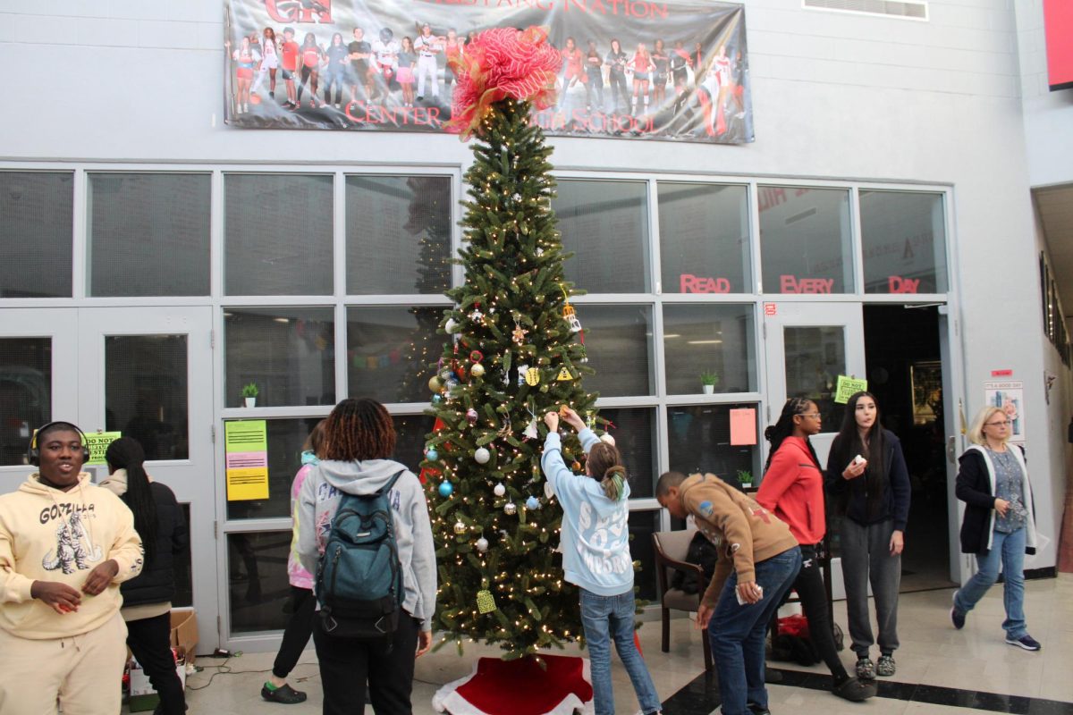 CH Students slowly filling the tree with colorful and decorative ornaments.