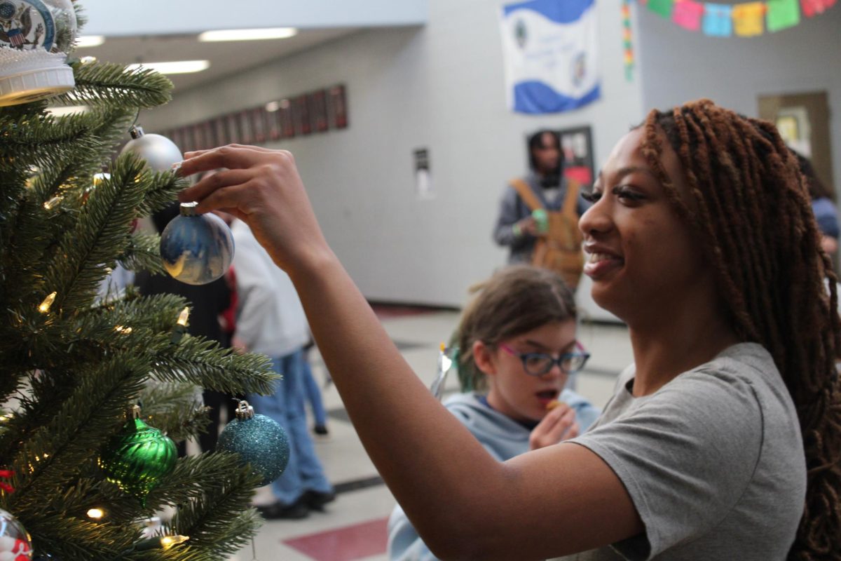 CH Student helping out with hanging of ornaments.